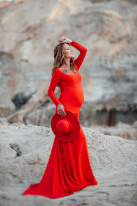 Midsection of woman with red umbrella standing outdoors