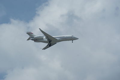 Low angle view of airplane flying against sky