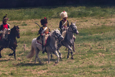 People riding horses on field