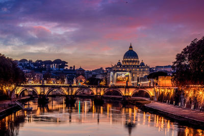 Illuminated bridge over river against sky during sunset