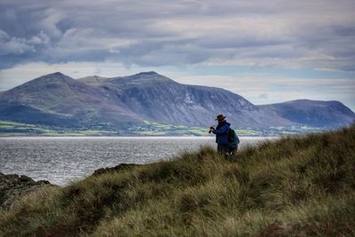 Rear view of friends on mountain against sky