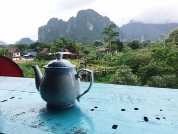 Close-up of drink on table against mountains