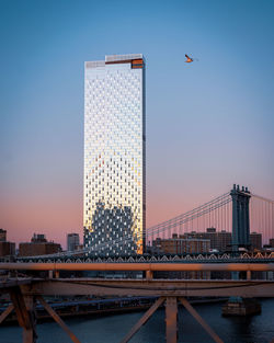 View of bridge and buildings against sky during sunset