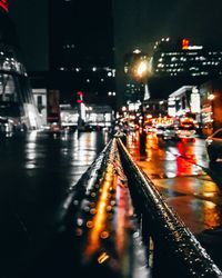 Illuminated city street during rainy season at night