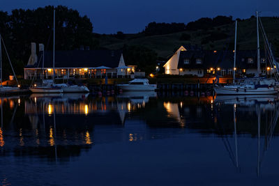 Boats moored in harbor at night