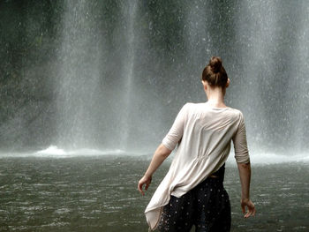 Rear view of woman standing in front of water