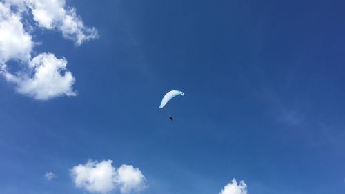 Low angle view of person against blue sky