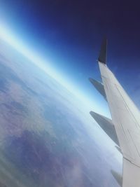 Airplane flying over clouds against blue sky