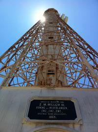 Low angle view of text on metal against sky