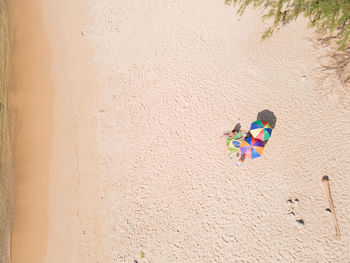 Full length of woman relaxing on sand at beach