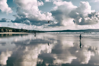 People walking on shore at beach