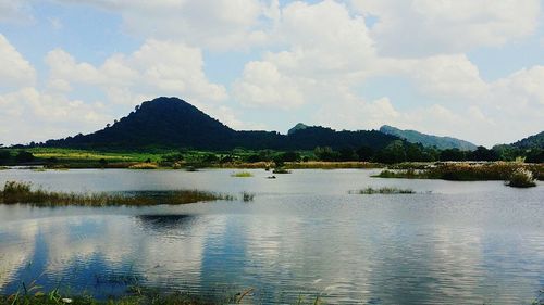 Scenic view of lake by mountains against sky