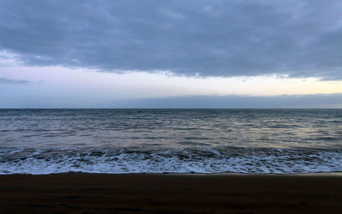 Scenic view of sea against cloudy sky