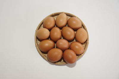 Directly above shot of eggs in container on white background