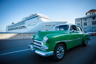 Vintage car in city against blue sky