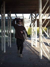 Full length of young man standing on footbridge