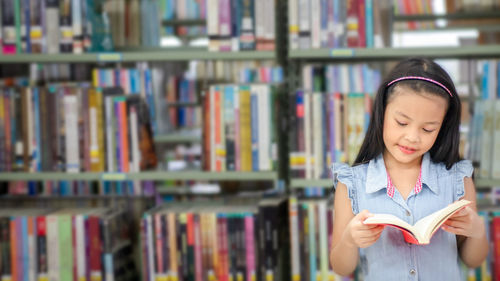 Full length of a young woman reading book