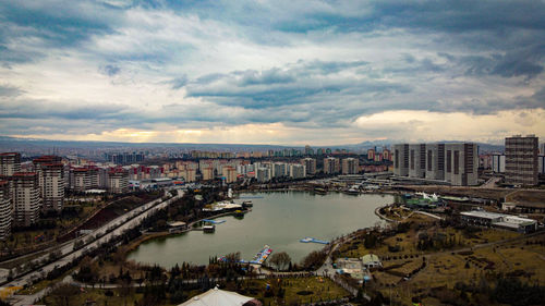 High angle view of buildings by river against sky