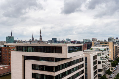 Buildings in city against cloudy sky