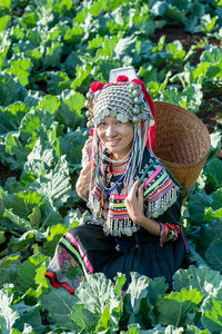 Woman wearing hat standing against plants