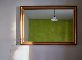 Electric lamp hanging against wall at home