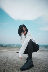 Woman standing at rooftop against sky