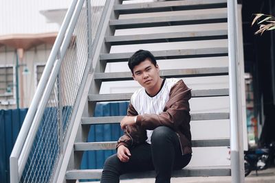 Portrait of young man sitting on staircase