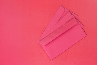 High angle view of pink paper on red table