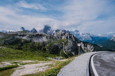 Road by snowcapped mountains against sky