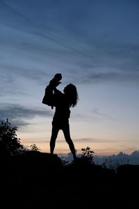 Silhouette couple standing against sky during sunset