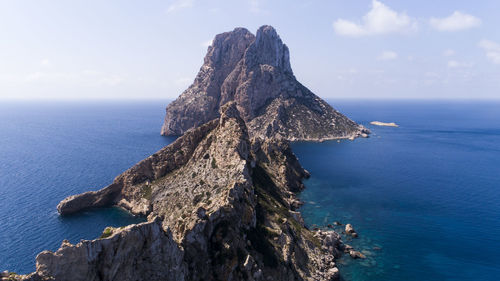 Rock formation in sea against sky