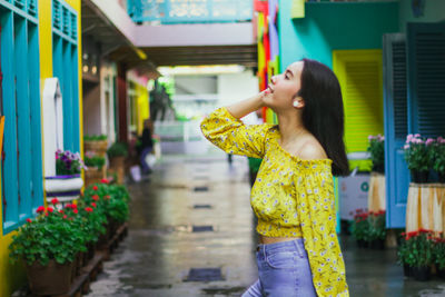 Side view of woman standing on footpath