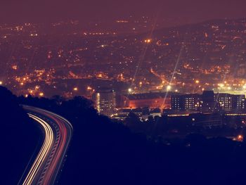 Illuminated cityscape against sky at night