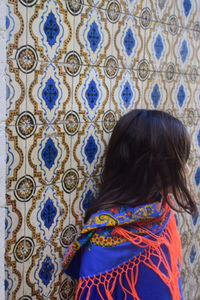 Girl standing against tiled wall