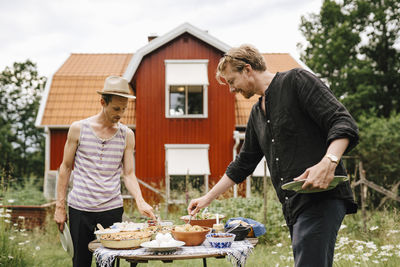 Men taking food from table in garden