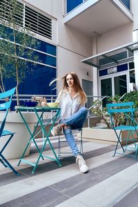 Portrait of young woman against building