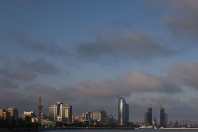 View of cityscape against cloudy sky