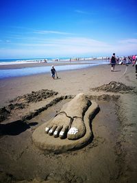 People on beach against sky