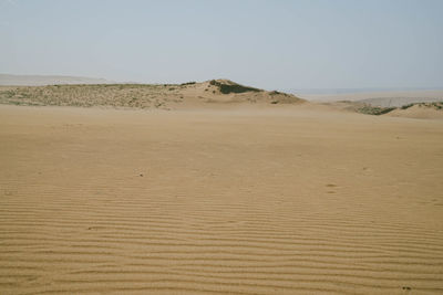 Surface level of sand dunes against sky