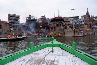 Boats in river against buildings in city