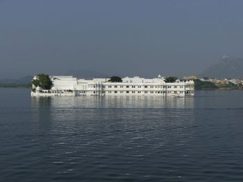 Scenic view of lake by building against clear sky