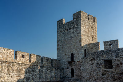 Low angle view of historic building against blue sky