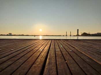 Boardwalk on pier against sky during sunset