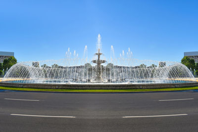 View of city buildings against clear blue sky