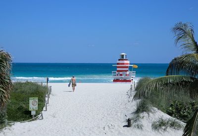 Man walking at beach against sky