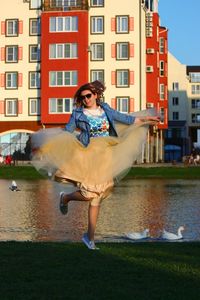 Woman dancing by canal in city