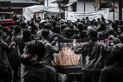 Rear view of people standing on street in city