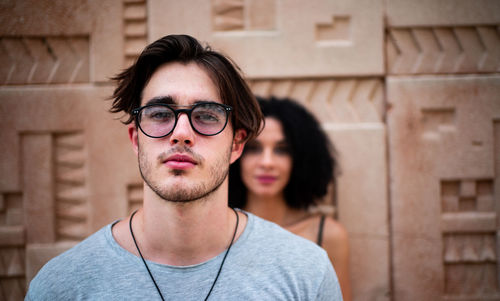 Portrait of handsome young man and a girl in the back 