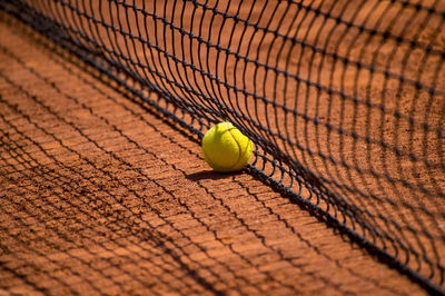 Tennis ball by net on field