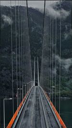 Footbridge in city against sky